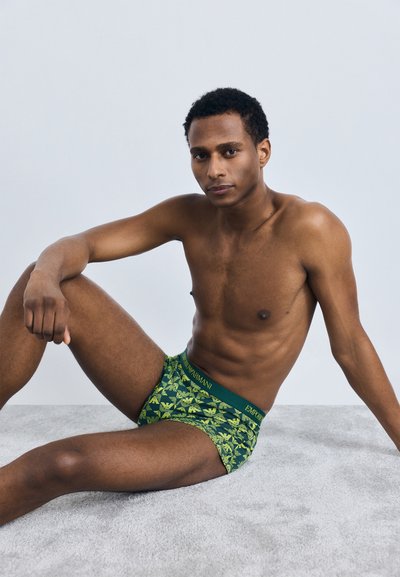 Žali ir geltoni raštuoti boxeriai, pagaminti iš minkštos medžiagos, su elastinga juosta, ant kurios užrašyta "Emporio Armani".