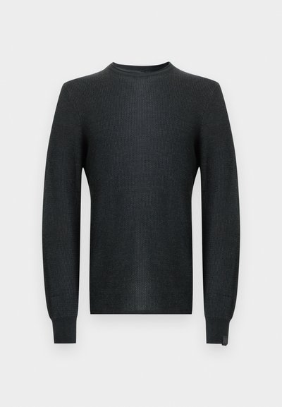 Dark grey knitted sweater with a round neckline, long sleeves, and ribbed cuffs. Features a textured fabric and a subtle logo tag on the hem.