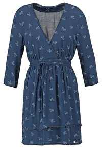 Robe bleue longueur genoux avec petits motifs floraux blancs, col en V croisé, manches longues et ceinture nouée à la taille.