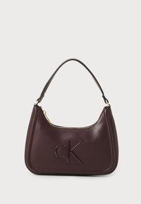 Bordeaux leren handtas met reliëf 'CK' logo, ronde vorm, enkele schouderriem en gouden ritsdetails.