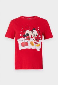 Red short-sleeve shirt with Mickey and Minnie Mouse dressed in Santa outfits, Minnie kissing Mickey on the cheek with snowflake background.