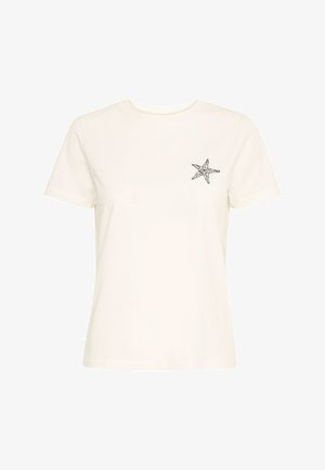 Kremasta pamučna majica kratkih rukava, s okruglim izrezom i crnom zvijezdom morskog ježunca na lijevoj strani prsnog dijela. Jednostavan, nenametljiv dizajn.