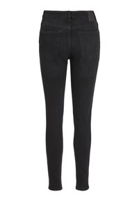 Jeans ajustados de mezclilla negra con una textura suave, diseño ceñido, cinturilla alta y dos bolsillos traseros. Presenta un dobladillo limpio y un detalle minimalista.