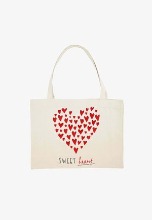 Canvas tote bag in natural color featuring a heart made of small red hearts. The design includes the text “SWEET heart” in black.