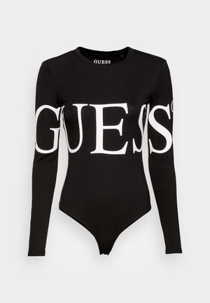 Bodysuit noir à manches longues arborant un grand logo blanc "GUESS" sur le devant, fabriqué en tissu coton extensible.