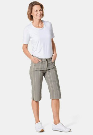 Lichtgrijze geruite kniebakken shorts met zakken, gecombineerd met een wit T-shirt met korte mouwen en witte sneakers. Gladde stoftextuur.