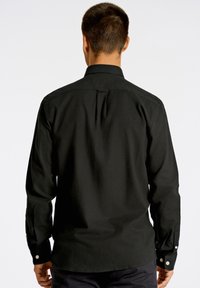 Maglietta nera a maniche lunghe, in tessuto di cotone testurizzato, colletto classico, polsini con bottone, dettaglio con piega sul retro, vestibilità su misura, adatta per un look casual o smart-casual.