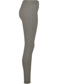 Fekete-fehér houndstooth mintás leggings, testhez simuló fazon, rugalmas anyag, magas derék, sima textúra, látható fémalkatrészek vagy díszítések nélkül.