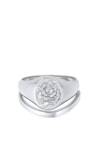 Bague en argent avec un devant ovale arborant un motif de rose en relief, une bande lisse et polie, et des éléments entrelacés pour un effet de superposition.