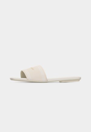 Sandale beige à bout ouvert avec une large bride en tissu et une semelle plate sur fond blanc.