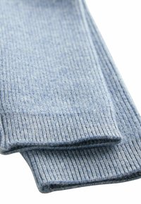 Calze a coste azzurro chiaro realizzate in morbido materiale tessile, con una superficie testurizzata e bordi piegati.