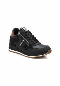 Zapatilla negra con un acabado de cuero suave y acentos texturizados. Cuenta con cordones, un zipper lateral y una suela de goma con un dibujo color marrón claro.