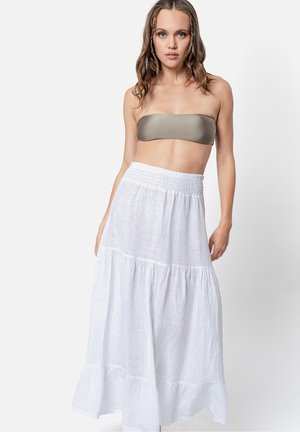 Witte, gelaagde maxi rok van lichte stof, met een smockband. Gedragen met een bandeau top in olijfgroen.