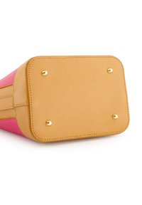 Multikleurige handtas met een roze en tan leren buitenkant, voorzien van vier gouden metalen bodemstuds en een textuurafwerking op de tan basis.