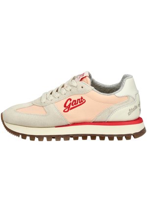 Tenisky s béžovým a broskvovým svrškem z semiše a kůže, s červenými akcenty a texturovanou hnědou gumovou podešví.