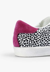 Białe sneakersy z czarowanym wzorem, fioletowym zamszowym akcentem na pięcie oraz teksturowaną białą gumową podeszwą, ukazujące kontrast materiałów i kolorów.
