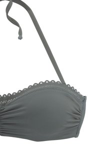 Top da bikini grigio con bordi scallop, spalline regolabili e dettagli arricciati. Realizzato in un tessuto liscio ed elasticizzato per il massimo comfort.