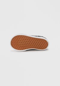 Semelle en caoutchouc pour sneaker, avec un dessous texturé de couleur beige, orné d'un motif géométrique, et bordé d'une lisière blanche. La partie supérieure lisse n'est pas visible.