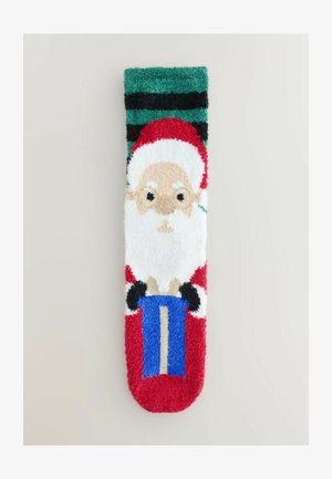 Calzini morbidi rossi e bianchi con un design di Babbo Natale che tiene un regalo blu, con un bordo striato verde e nero in cima. Texture soffice.
