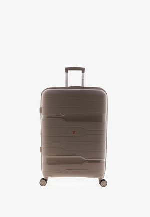 Valigia rigida in plastica marrone chiaro, con texture ondulata, manico retrattile e quattro ruote per una facile mobilità.