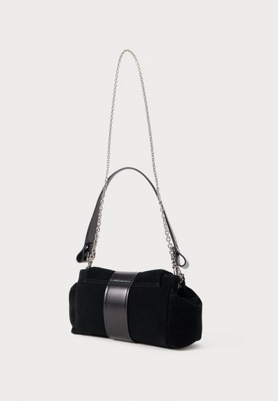 Bolsa de mão em camurça preta com uma faixa de couro preto brilhante, corrente e alça de couro, apresentando um formato retangular arredondado.
