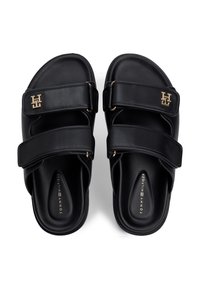 Μαύρα σανδάλια τύπου slide από συνθετικό υλικό, με δύο ρυθμιζόμενες λουράκια με βέλκρο και χρυσή διακοσμητική λεπτομέρεια με λογότυπο στο πάνω λουράκι.