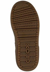 Braune Gummischuhsohle mit einem strukturierten Muster aus Rillen und Perforationen, versehen mit der Marke "GEOX" und der Inschrift "ITALIAN PATENT".