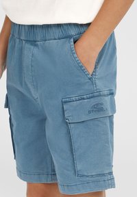 Blå cargoshorts i lättviktig tyg, med elastisk midja, sidofickor och en ficka med broderad logotyp.