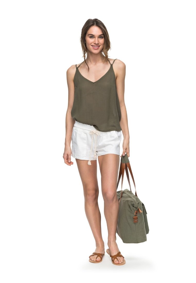 Olive green sleeveless top, white drawstring shorts, brown sandals, and a green bag with brown straps. The fabric appears lightweight and casual.
