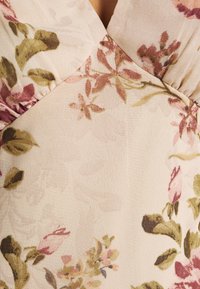 Tela con estampado floral en colores suaves, que incluye tonos de rosa empolvado, verde y beige. Material texturizado y ligero con un diseño fluido.