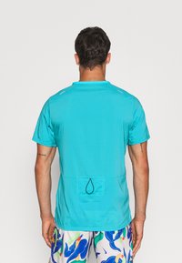 Tyrkysové sportovní tričko s krátkým rukávem, zaobleným výstřihem, texturovanou tkaninou a zadní kapsou se šňůrkovým detailem.