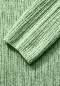 Ribbed knit-svett med ljusgrön färg; har en mjuk textur och långa ärmar med vikta manschetter för en snug passform.