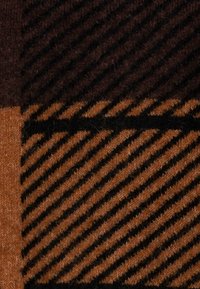 Wolltextil mit einer braunen und orangefarbenen Farbpalette; enthält einfarbige und gestreifte Muster mit verschiedenen Texturen, die Wärme und Weichheit zeigen.
