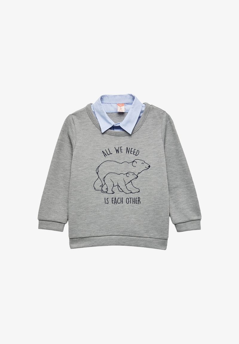 Szary sweter z długimi rękawami i okrągłym dekoltem. Pod spodem znajduje się jasno-niebieska koszula z kołnierzykiem, z haftowanym wzorem białego niedźwiedzia i napisem.