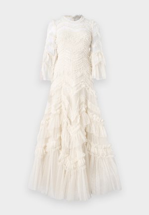 Bílé šaty s volánovými vrstvami, texturovaným materiálem s puntíky, dlouhými průhlednými rukávy a vysokým výstřihem.