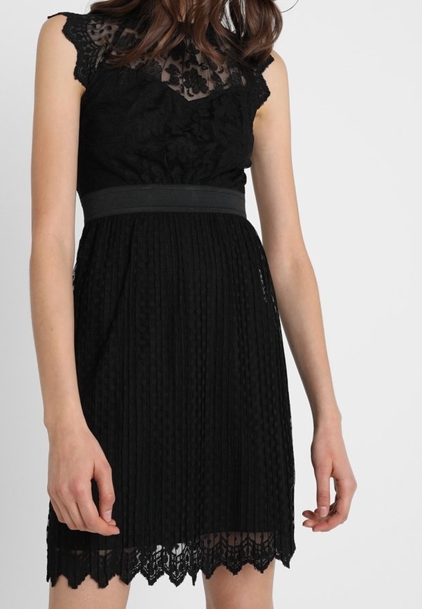 Robe noire avec corsage en dentelle et manches courtes, jupe plissée, ceinture en tissu à la taille, et ourlet en dentelle festonné.