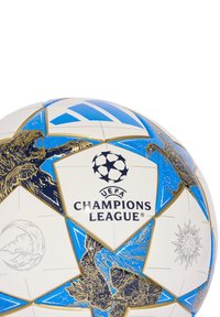 Valkoinen jalkapallo, jossa on sinisiä ja kultaisia yksityiskohtia, UEFA Champions League -logo, tähtikuvio ja yksityiskohtaiset grafiikat eläimistä ja muodoista.