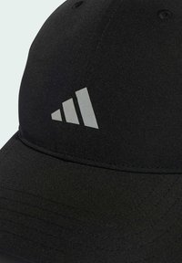 Gorra negra hecha de tela texturizada con un logo de tres franjas grises en la parte frontal, visera curva y detalles cosidos.