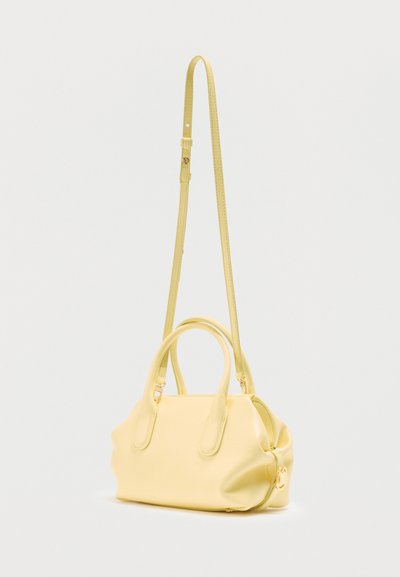 Μαλακή κίτρινη δερμάτινη τσάντα χειρός με διπλές κοντές λαβές και μακρύ ρυθμιζόμενο λουρί ώμου, απεικονίζεται σε απλό ανοιχτό φόντο.