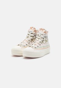 High-top sneakers featuring a white canvas upper with animal print patterns, metallic accents, and a textured rubber sole.