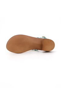 Sandalini azzurro chiaro con tomaia in pelle liscia, dotati di una cinghia alla caviglia e una suola in gomma color terra arrotondata con una texture rigata.