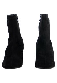 Botines de ante negros con forma afilada, cierre de cremallera lateral y una textura suave, que cuentan con un sutil detalle de costura en la parte delantera.