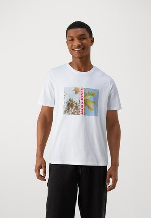 T-shirt bianca in cotone con una grafica di palme e cielo blu, con "JACK & JONES" in testo rosso sulla parte anteriore. Maniche corte.