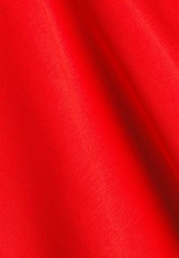 Tissu rouge avec une texture lisse et légèrement brillante, présentant des fibres tissées serrées et des variations de couleur subtiles. Aucun motif ni détail supplémentaire.