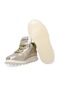 Massief gouden sportschoenen met een geperforeerd ontwerp, groene accentvoering, platte veters en een rubberen zool met kleine gripnoppen.