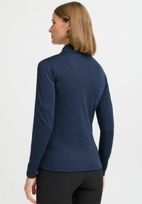 Navy long-sleeve top with a fitted design and textured fabric. Features a high collar and side seams, suitable for active wear.