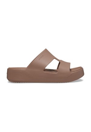 Braune Rutsch-Sandalen aus leichtem Material, mit einem breiten Riemen mit Ausschnitten, einer dicken Plattformsohle und einer strukturierten Unterseite für besseren Halt.
