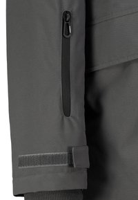 Gray jacket fabric with a smooth texture, featuring a zippered pocket and Velcro strap on the cuff. Includes a structured design.