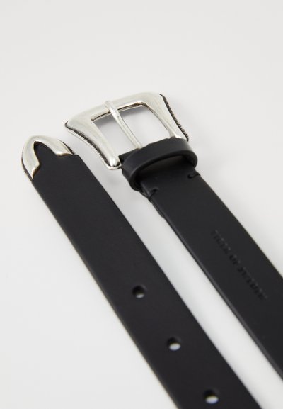 Cinturón de goma negra con una hebilla de metal plateado. Presenta una textura suave, extremo puntiagudo y varios agujeros para ajuste.
