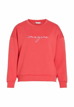 Koralowa bluza dresowa o luźnym kroju, z zaokrąglonym dekoltem i raglanowymi rękawami. Na przodzie w białym haftowanym napisie widnieje słowo "Imagine".